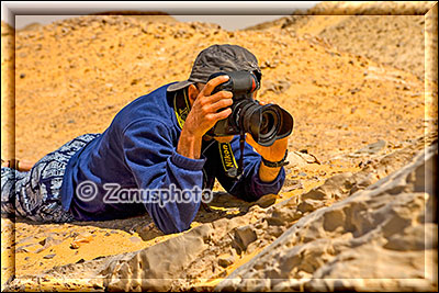 Fotograf mit Kamera am Boden liegend