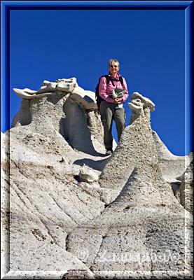 Frau steht hoch oben an kleinen Hoodoos