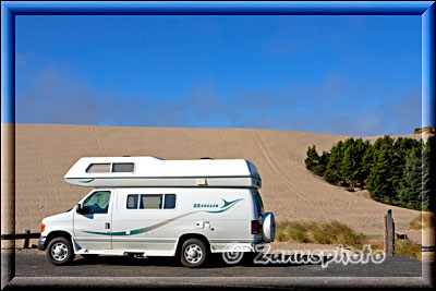 VAN-Camper parkt neben riesiger Sanddüne