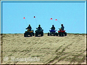 Vier Sandbuggys am Kamm einer Sanddüne