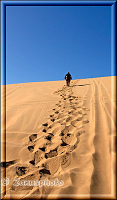 Fussspuren im Sand einer steilen Düne