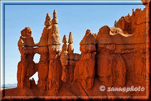 Rote Hoodoos mit kleinem Arch in der Mitte.