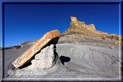 Rötlicher Fels mit brauner Bergspitze im grauen Umfeld