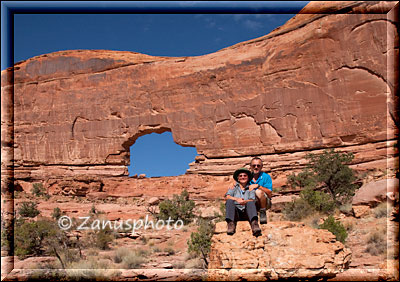 Jeep Arch, die beiden Wanderer haben den Arch erreicht und sitzen für ein Foto davor