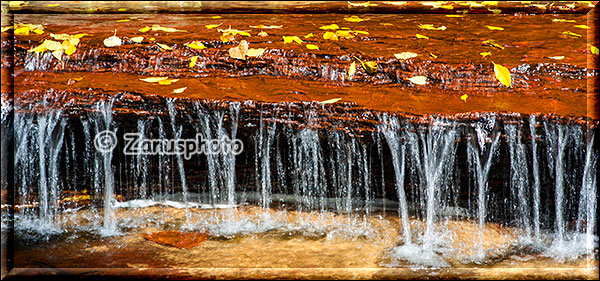 Kleine Wasserfälle an Felsstufe im Bett des Creek