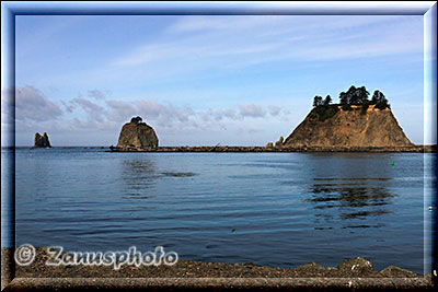 Vom Strand aus sind mehrere Sea Stacks im blauen Ozean zu sehen