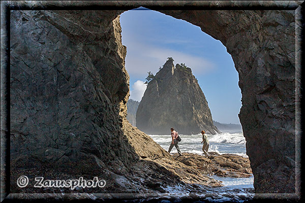 Zwei Wnaderer durchqueren Hole in the Rock