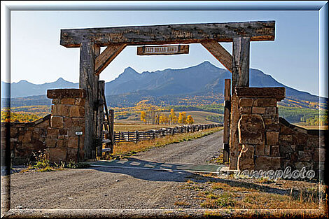 Last Dollar Road mit Aussicht auf eine Ranch neben der Road