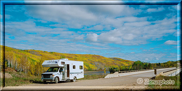 Camper steht am Yellowknife Highway vor gelbem Wald