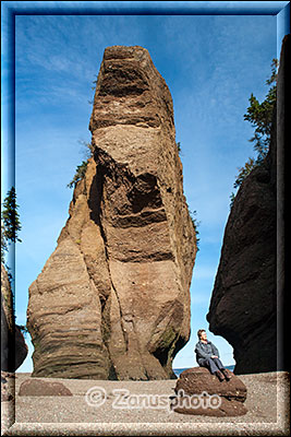 Grössenvergleich zwischen Felsturm und Frau auf einem kleinen Felsen