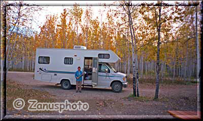 Frau mit Axt vor einem Camper